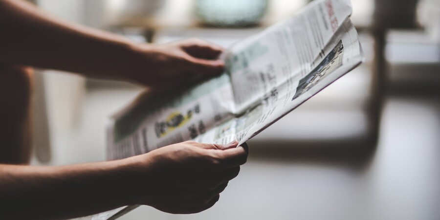 Image of a person holding a news paper.