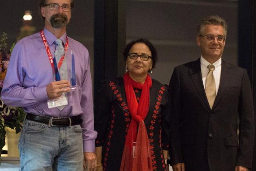 Dr. Lothar Lilge (left) receiving the 2019 Lifetime Achievement Award from IPA Past-President, Dr. Tayyaba Hassan (center), and IPA President, Dr. Luis Arnaut (right)